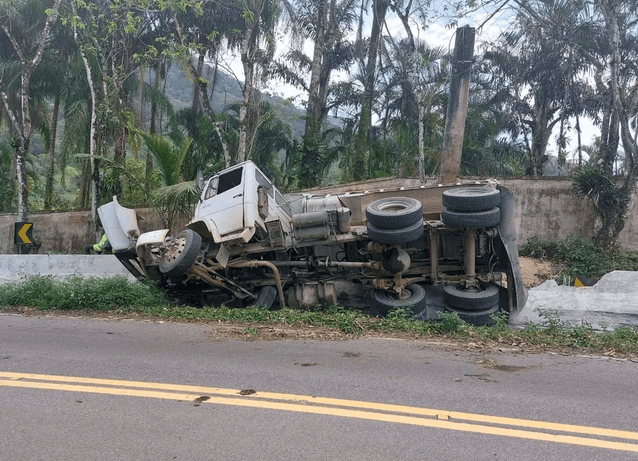 Caminhão com carga de areia tomba e motorista fica ferido em São Sebastião