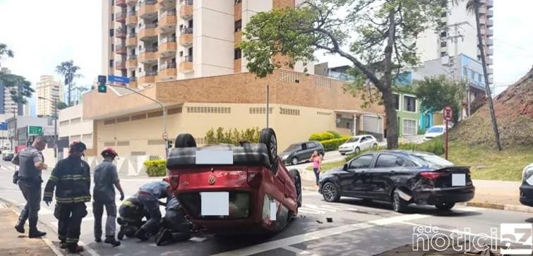 Carro bate em outro, capota e uma pessoa fica presa nas ferragens